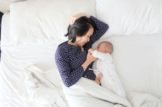 Maman et bébé détendus sur un lit, moment de confort