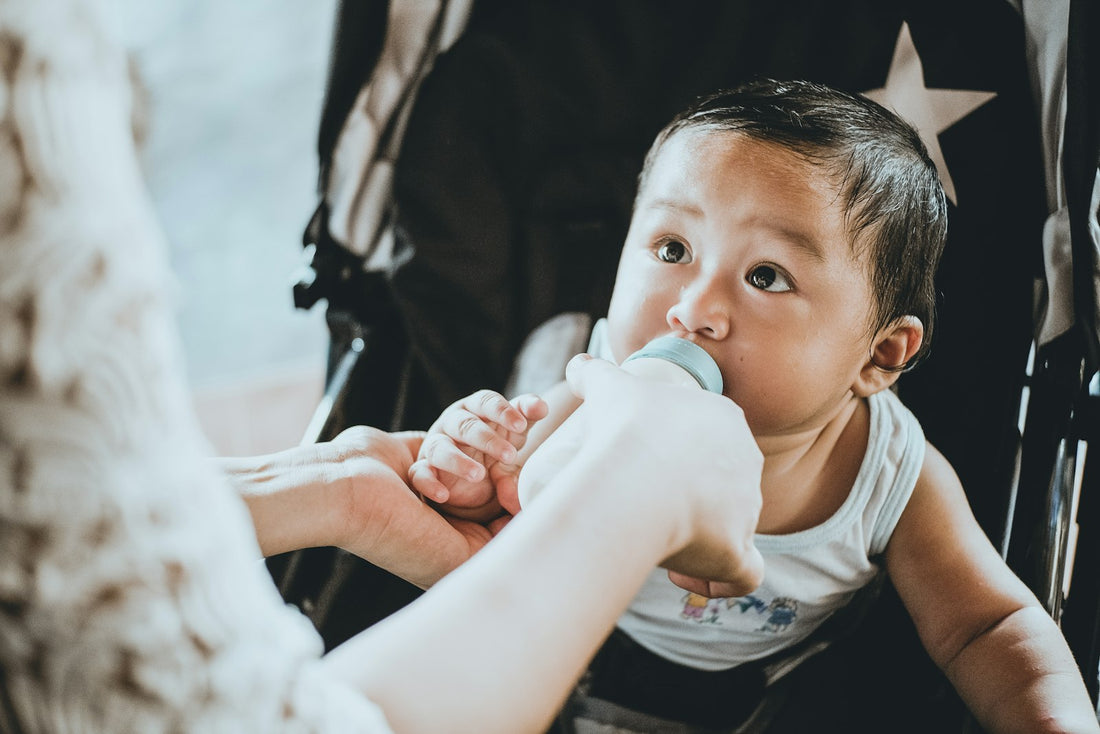 Un parent donne le biberon à un bébé dans une atmosphère douce et calme